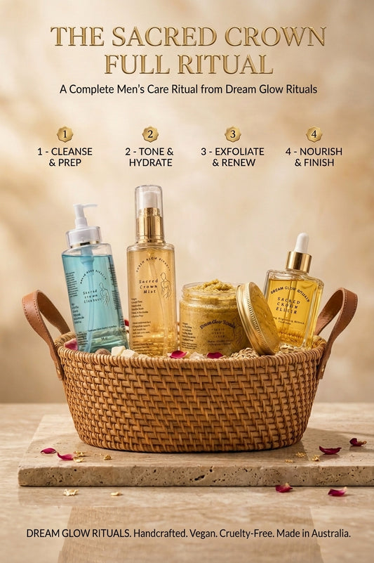 A men's skincare ritual set displayed in a woven wicker basket on a stone surface, with four bottles and a jar arranged under the heading 'THE SACRED CROWN FULL RITUAL.' The products include a blue bottle, a tall gold-toned bottle, a small gold-toned bottle, and a yellow-green jar, with rose petals scattered around.